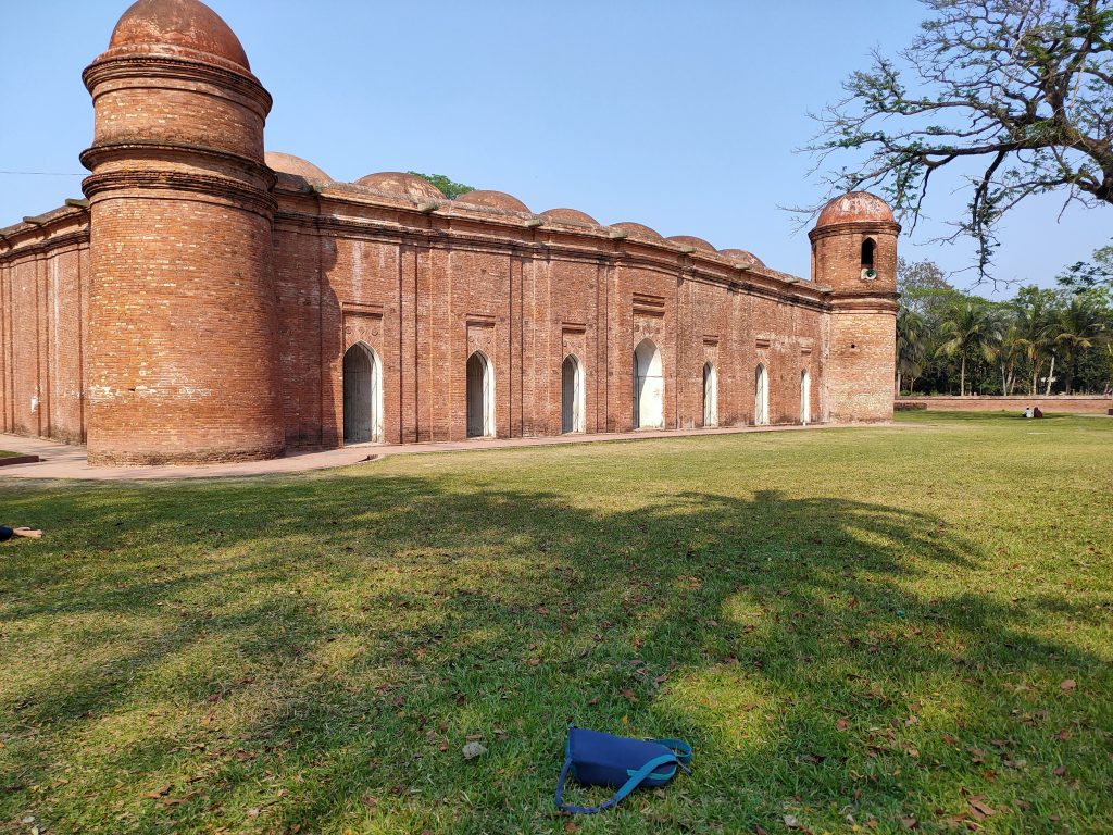 Exterior view of Shat Gombuj Mosque showcasing its 77 domes and architectural splendor in Bagerhat.